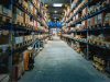 Ein grosses Warenlager mit Regalen links und rechts ziert das Bild